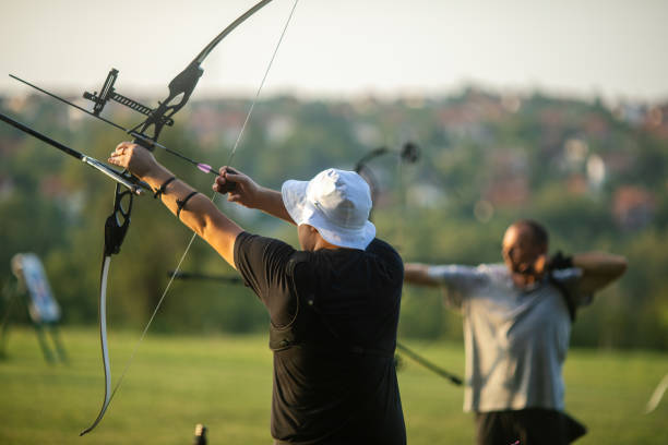 istock Teenage boy and a man practicing archery with recurve and compound bow on the training field 2166849988