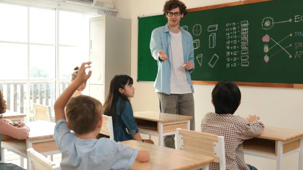 istock Energetic boy raised hand and volunteer to write answer on blackboard. Pedagogy. 2166850077