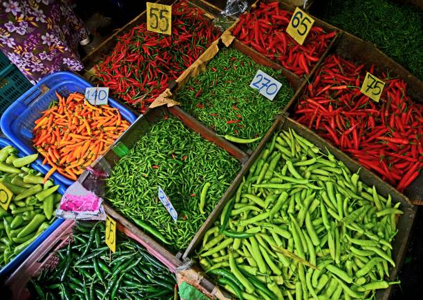Vibrant red chili peppers, neatly arranged on six plates, three pink and three light-toned, resting on a dark green fabric surface. A fresh and spicy ingredient, perfect for culinary use.
