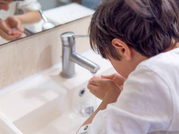 istock A boy washing his face under running tap 2166852680