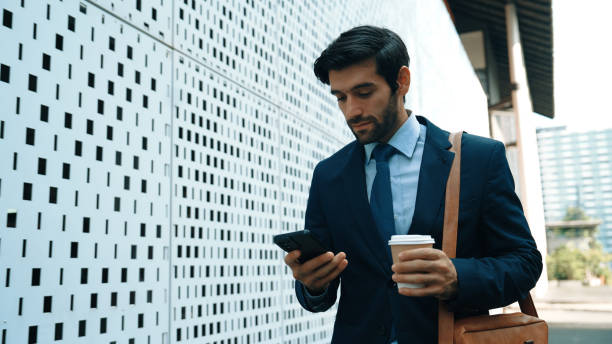 istock Professional manager looking at mobile phone while walking at street. Exultant. 2166853173