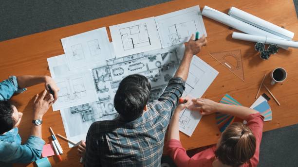 istock Group of diverse team looking at blueprint while brainstorming idea. Symposium. 2166854158