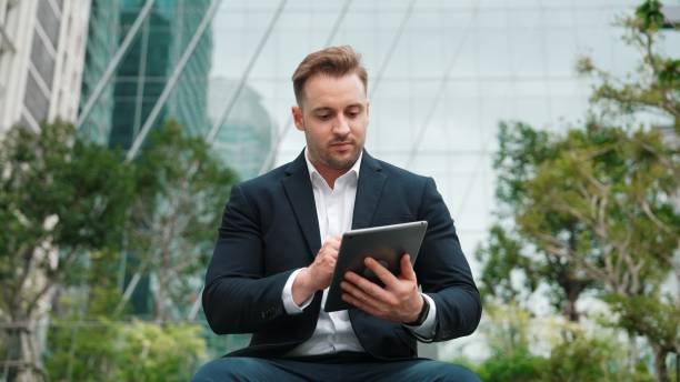 istock Smart businessman sitting while writing on tablet and planning strategy. Urbane 2166854669