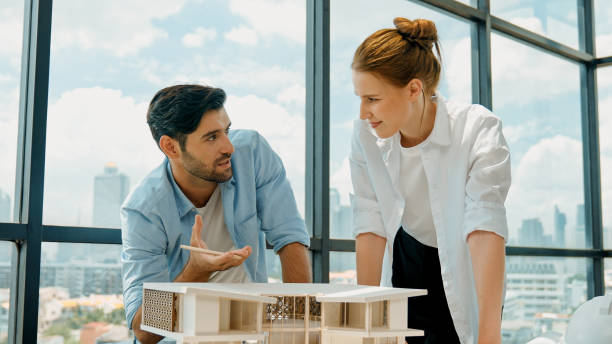 istock Skilled architect team discussion about house model construction. Tracery 2166856238