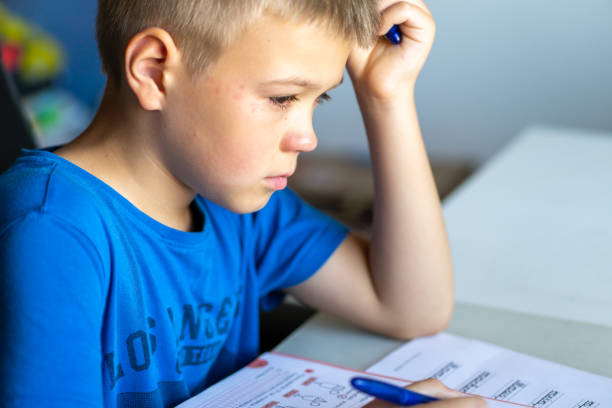 A boy in a blue T-shirt is crying over school