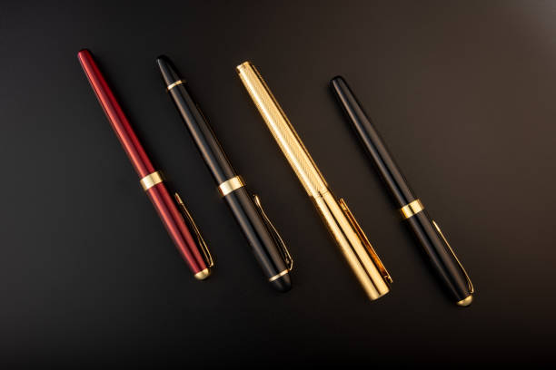 Fountain pens, beautiful fountain pens positioned on dark background, selective focus.