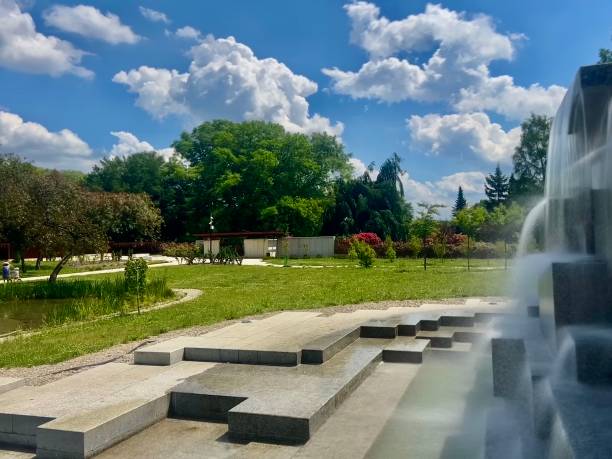 istock Fountain in the park on a background of blue sky with clouds. 2166860133