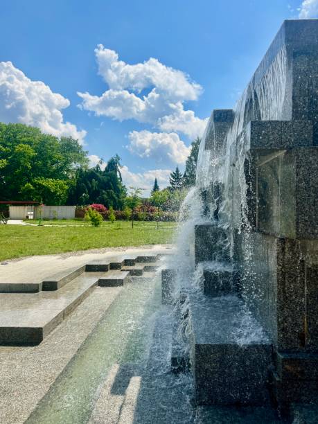 istock Fountain in the park on a background of blue sky with clouds. 2166860135
