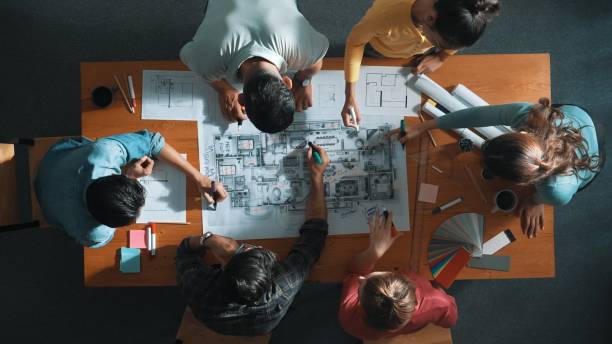 istock Top down view of engineer team writing at blueprint at meeting table. Symposium. 2166861086