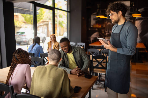 istock Waiter taking orders from customers in a pub 2166862625