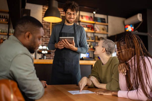 istock Waiter taking orders from customers in a pub 2166862652
