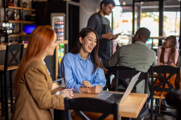 istock Two women using a laptop in a pub 2166862825