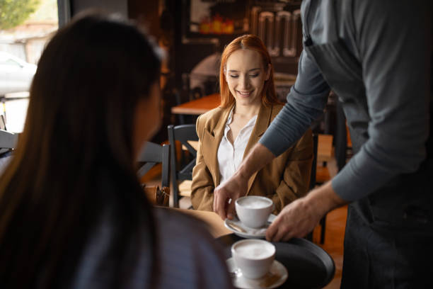 istock Waiter bringing coffee to two women in a pub 2166862917