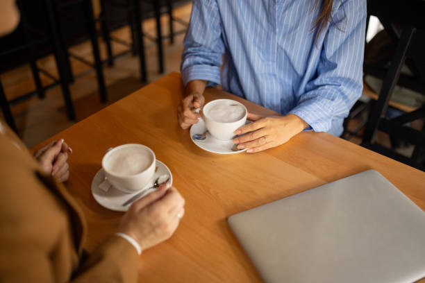 istock Two women talking and drinking coffee in a pub 2166862992