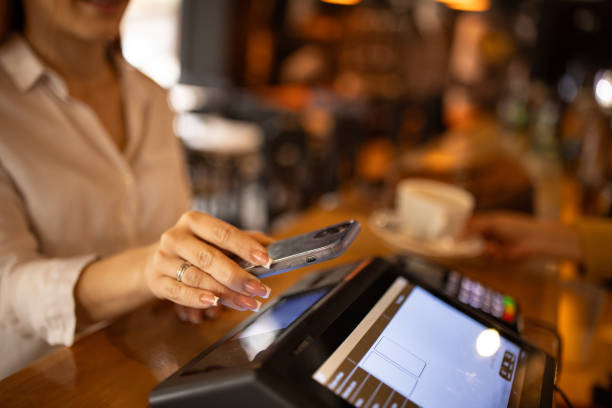 istock Woman using her phone to pay for coffee in a pub 2166863392