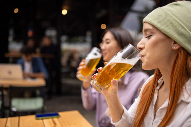 istock Two women drinking beer together in a pub 2166863897