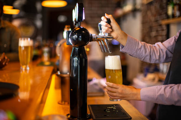 istock Bartender pouring beer from a tap into glasses 2166864218