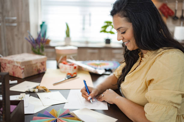 istock Woman crafting handmade cards at a kitchen table during the afternoon 2166865708
