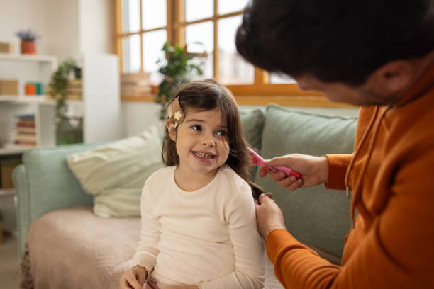 istock Father brushing his daughters hair at home 2166869199