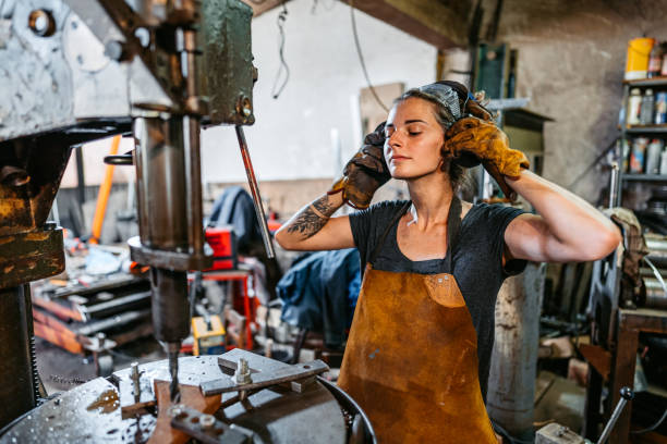 istock Young Woman Putting On Protective Earwear Before Working On A Drill Press In A Metal Workshop 2166869810