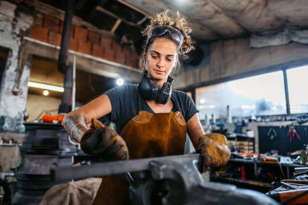 istock Young Woman Working On A Thin Metal Rod In A Workshop 2166870235