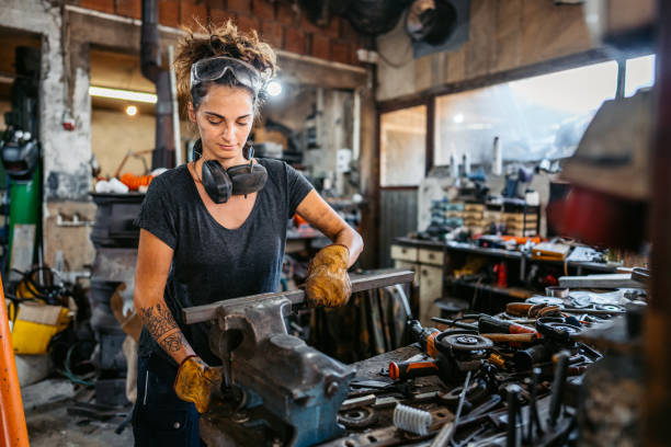 istock Young Woman Working On A Thin Metal Rod In A Workshop 2166870621