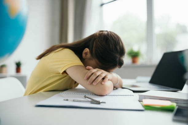 istock A young girl studies at home, feeling overwhelmed during her remote learning session 2166870650