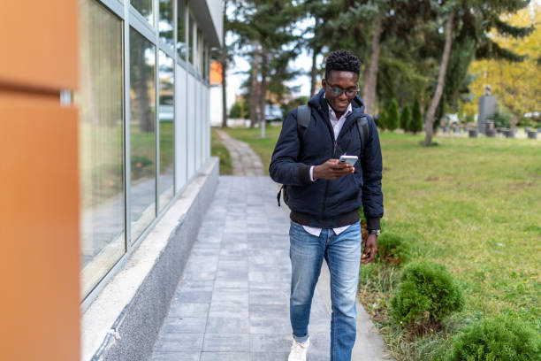 istock Young man walking outdoors and using his phone 2166871953