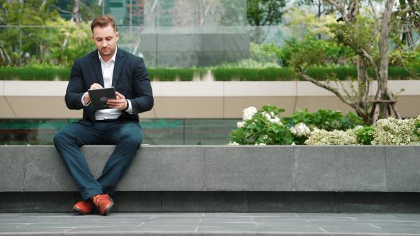 istock Smart businessman sitting while writing on tablet and planning strategy. Urbane 2166872614