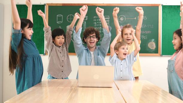 istock Teacher and student looking at laptop while celebrate success project. Pedagogy. 2166874151