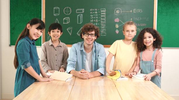 istock Teacher and student looking at camera while boy standing at board. Pedagogy. 2166876626