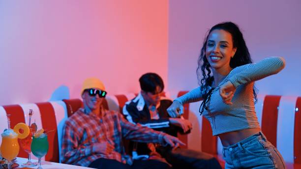 Hispanic dancer perform movement while diverse friend sitting and dancing together. Happy professional hipster moving hand while multicultural group supporting and encouraging friend. Regalement.