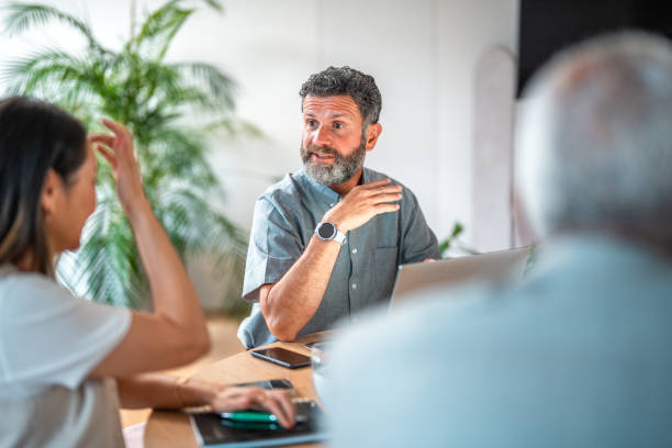 istock Smiling Senior Professional in Diverse Office Discussion 2166883345