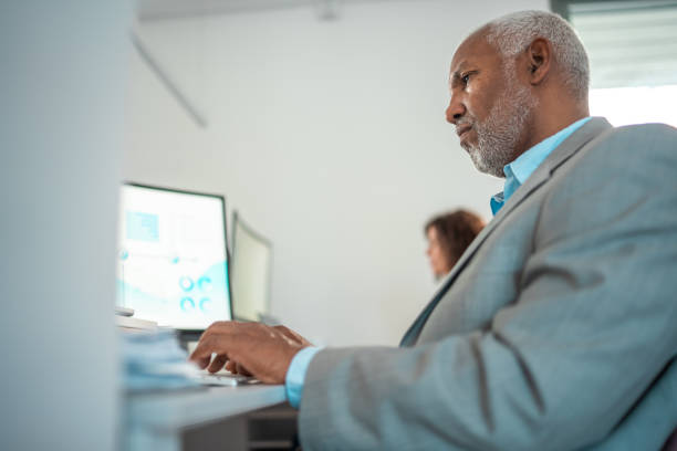 istock Senior Hispanic Executive Working at Modern Office Desk 2166883745