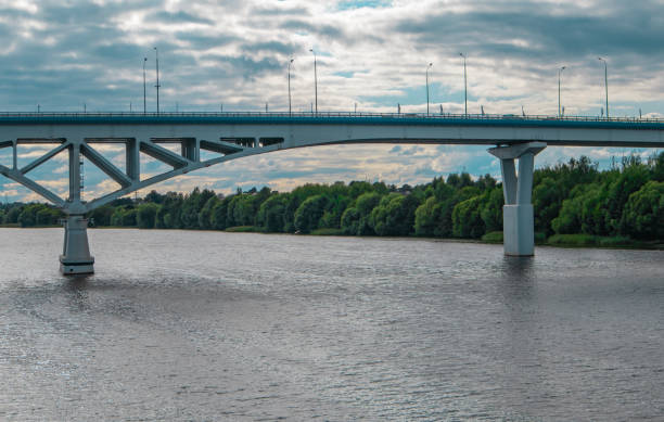 istock View of a large automobile bridge over a wide river against a cloudy sky 2166885585