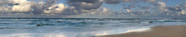 istock Panoramic view of a dramatic ocean scene with crashing waves under a cloudy sky 2166888164