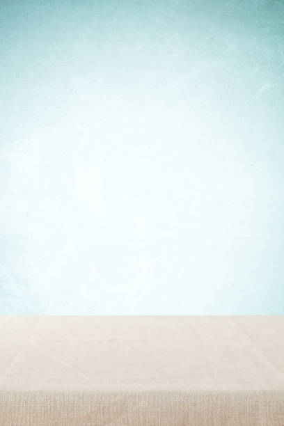 istock Empty table with linen tablecloth over blue concrete wall background, banner, table top, shelf, counter design for food and product display montage, vertical 2166888266
