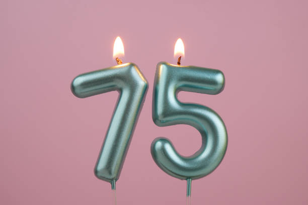 istock Blue birthday candles on pink background, number 75 2166889216
