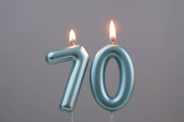 Blue birthday candles on gray background, number 70