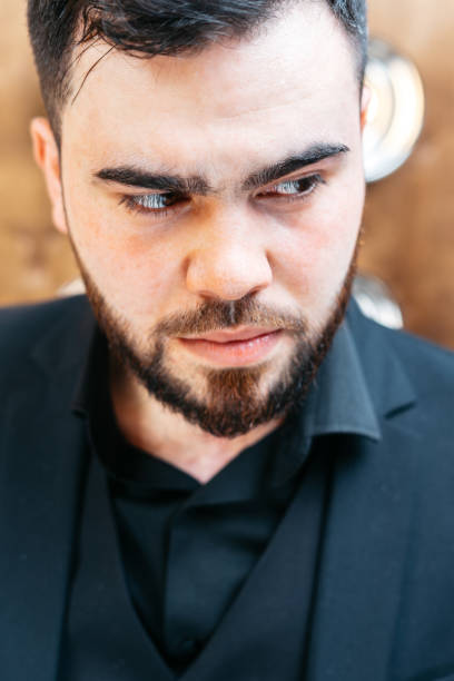 serious stylish attractive young man with a beard wearing formal clothes