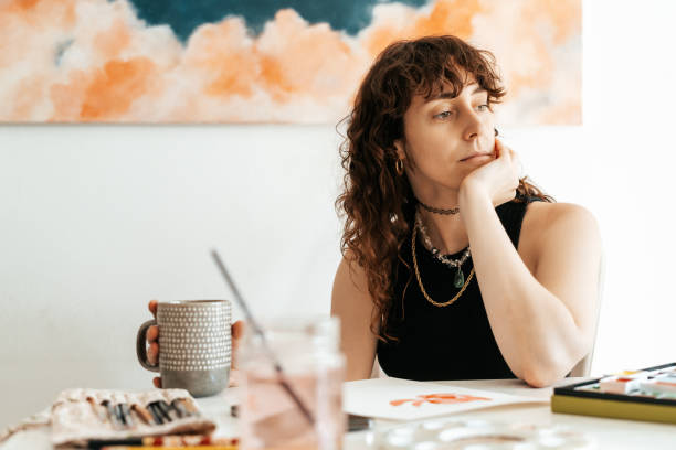 istock woman artist takes a break while holding a cup 2166891346