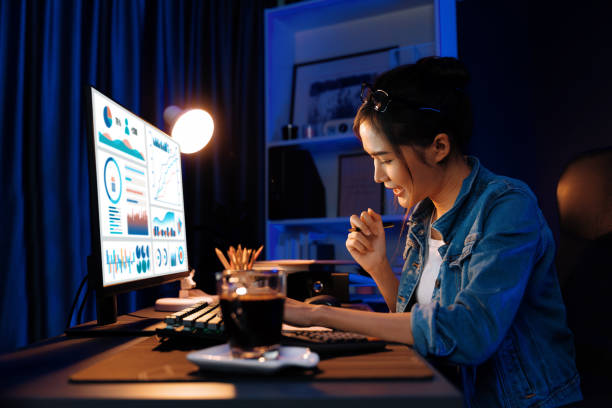 istock Smiling Asian creative looking pc of report and writing on notebook. Stratagem. 2166895830