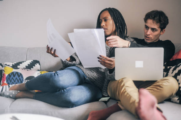 istock Couple Reviewing Documents on Couch with Laptop at Home 2166899856