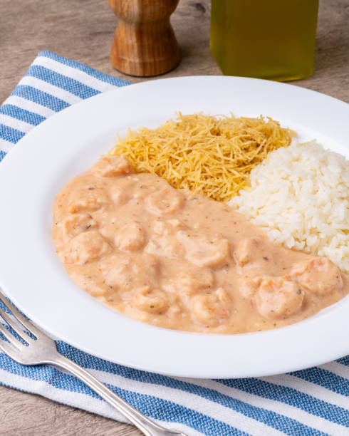 istock Shrimp strogonoff with rice and straw potato over wooden table 2166905443
