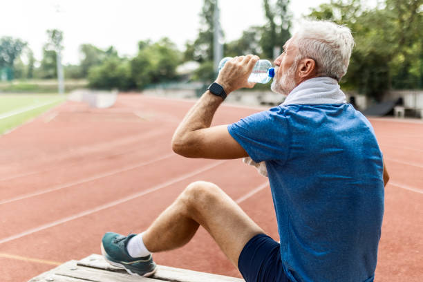 istock Senior Man Taking a Water Break on a Bench 2166907424