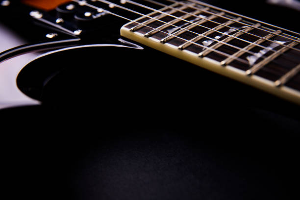 Detailed macro shot of an electric guitar showing the tone control knobs. The image captures the texture and design of the instrument, perfect for concepts related to music, sound, and creativity.