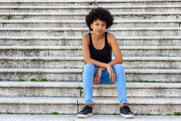 istock Young black girl sitting on a staircase alone 2166912604