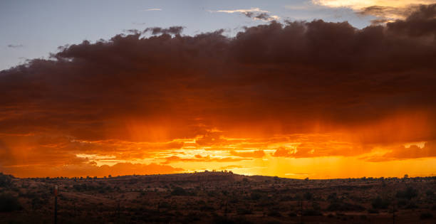 A panorama of a stunning sunset over a ridge in silhouette.