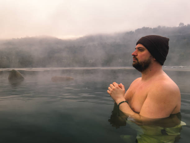 istock Man in Beanie Meditating in Steamy Hot Spring 2166916935