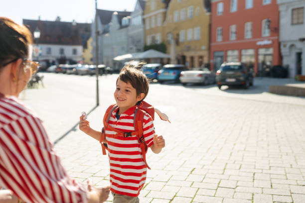 Photo of a smiling young boy greeting with his mom after \